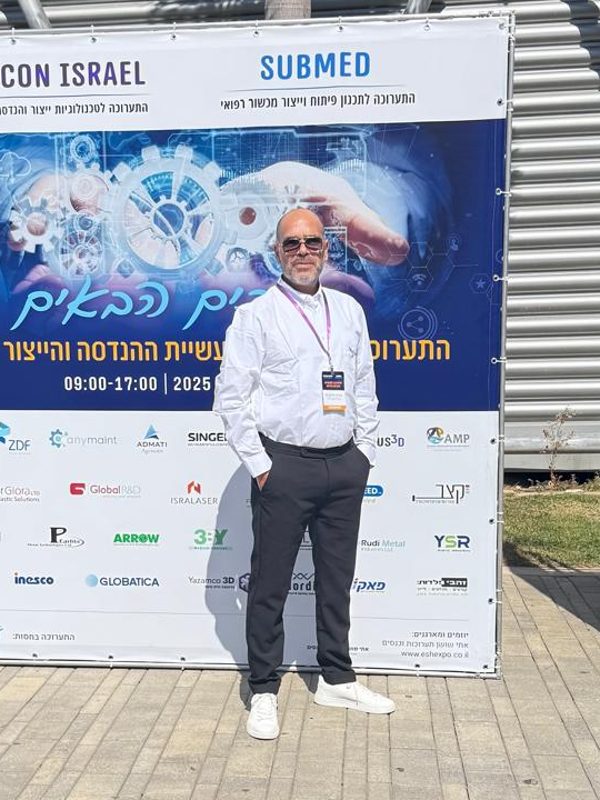 Isac, MEKLYRA's founder, standing in front of the SUBCON Israel exhibition banner